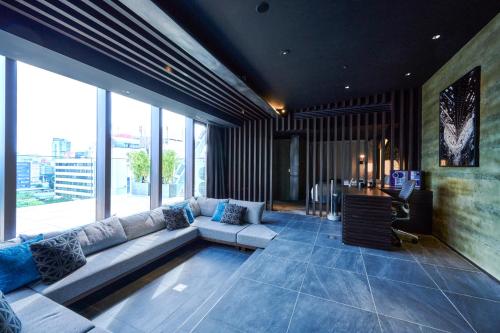 a living room with a couch and a table at The Tower Hotel Nagoya in Nagoya