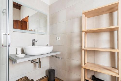 La salle de bains est pourvue d'un lavabo et d'un miroir. dans l'établissement Italian Experience-Uriel Suite Apartment, à Corteolona
