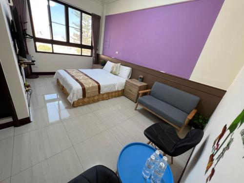 馬公市的住宿－幸福陽光民宿，一间卧室配有一张床和紫色的墙壁