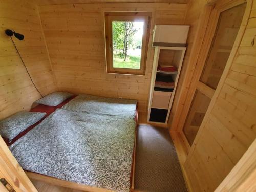 Una pequeña habitación con una cama y una ventana. en HeartSPAce Taszów, en Taszów