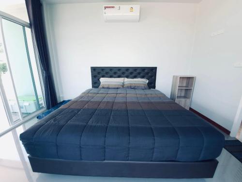 a large blue bed in a room with a window at Vanilla Sky @Khao Yai in Ban Bung Toei