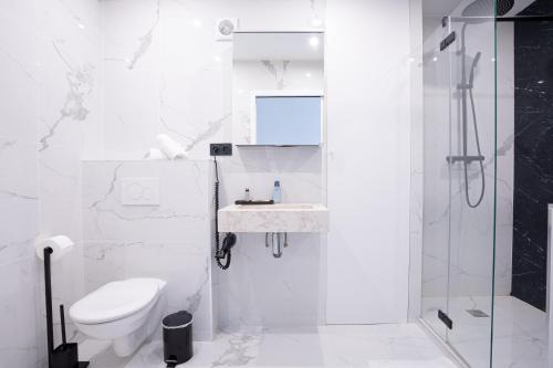 une salle de bain blanche avec toilettes et douche dans l'établissement 
