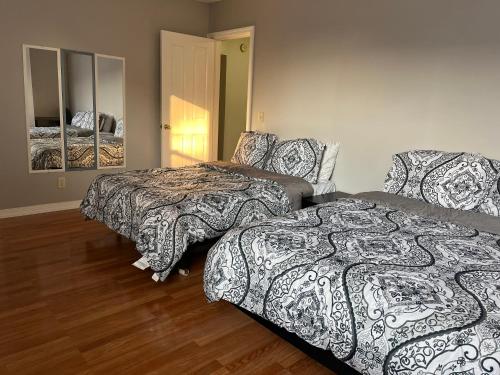 a bedroom with two beds and a mirror at Lovely three Bedroom Apartment near Jersey city and Newyork in Linden