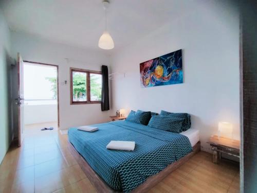 sypialnia z łóżkiem z niebieską kołdrą w obiekcie Ten RooMs w mieście Telukbakau