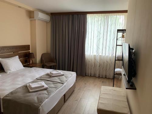 1 dormitorio con 1 cama, TV y ventana en Villa Vitis en Kvareli