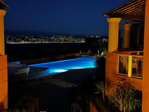 uma vista para uma piscina à noite em Vue mer et sur la baie de Cannes piscine 450m2 randonnée VTT au pied de l Esterel em Théoule-sur-Mer