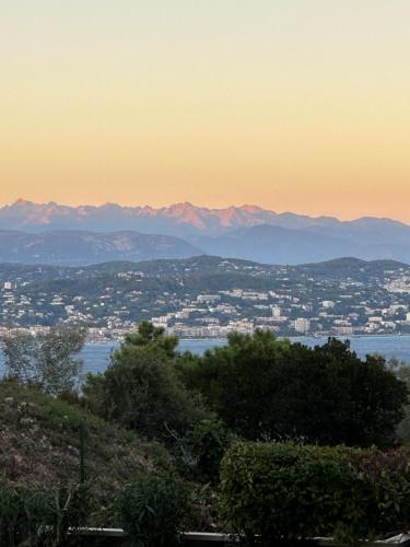 a view of a city with mountains in the background at Vue mer et sur la baie de Cannes piscine 450m2 randonnée VTT au pied de l Esterel in Théoule-sur-Mer