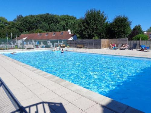 a large blue swimming pool with people in it at Bergh & Duin - lakens, elektriciteit en water inbegrepen in De Panne