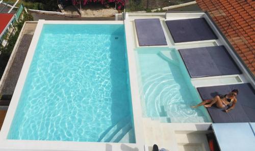 two people swimming in a swimming pool at ThalaSEA Apartments in Chrani