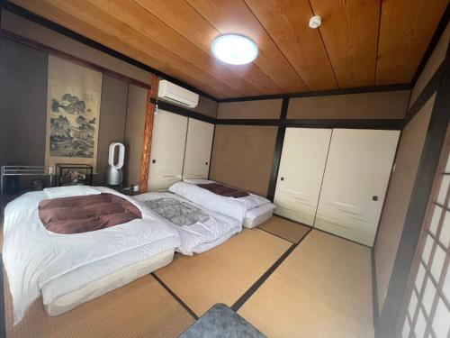 two beds in a room with wooden ceilings at Fukurou no Oyado - Vacation STAY 71438v in Fuefuki