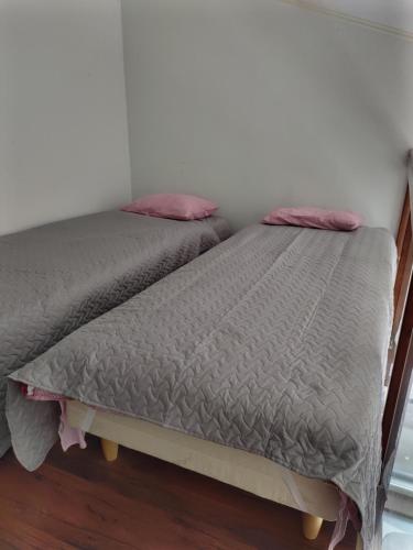 two beds sitting next to each other in a room at Walhalla apartment in Forssa