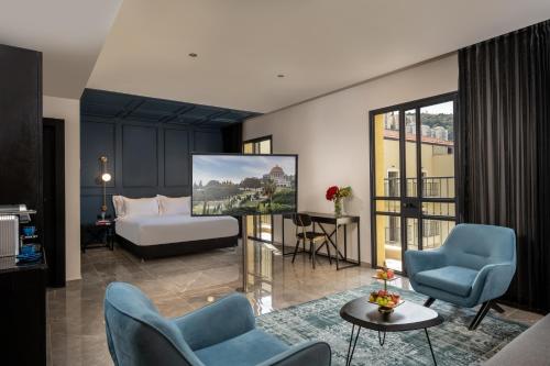 um quarto de hotel com uma cama e cadeiras e uma sala de estar em Hotel Botanica- Limited Edition By Fattal em Haifa