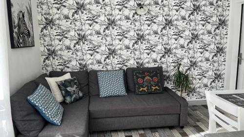 a couch in a living room with a floral wallpaper at 100 m de la mer, Sauna, Wifi in Mers-les-Bains