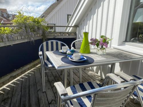 una mesa y sillas en un balcón con mesa y sillas en Bekvämt boende mitt i gamla genuina Skärhamn en Skärhamn