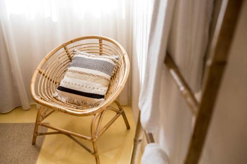 a wicker chair with a pillow in a room at SeaYa Villas in Cascais