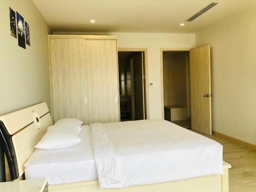 a bedroom with a large white bed with two pillows at Gold Coast Luxury Apartment Nha Trang in Nha Trang