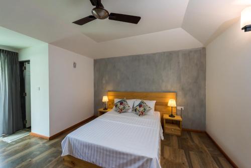 a bedroom with a white bed with two lamps at Isla Dhiffushi in Dhiffushi