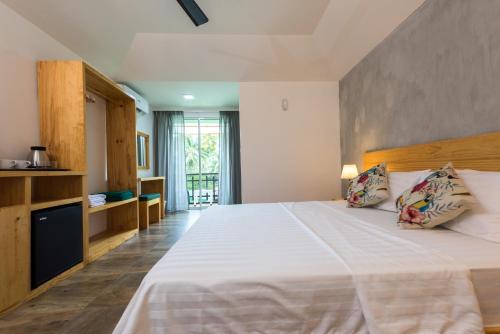 a bedroom with a large white bed with two pillows at Isla Dhiffushi in Dhiffushi