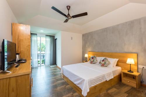a bedroom with a bed and a ceiling fan at Isla Dhiffushi in Dhiffushi