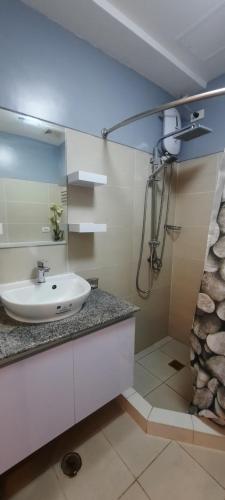 a bathroom with a sink and a shower at Epie's Pad in Tagaytay