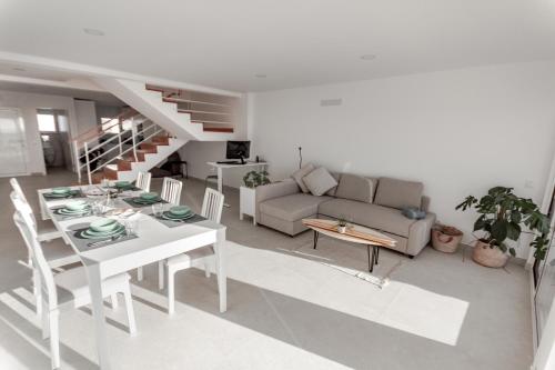 een woonkamer met een tafel en een bank bij Arrifana Sunset Sea View Villa in Praia da Arrifana