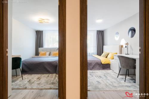a bedroom with a bed and a desk in a room at Long street suites in Braşov