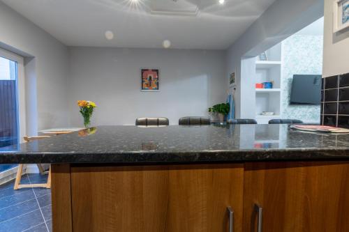 eine Küche mit einer schwarzen Arbeitsplatte in einem Zimmer in der Unterkunft 3 bedroom home and garden in North Bristol in Bristol