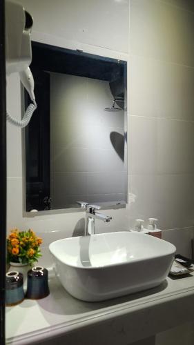 a bathroom with a white sink and a mirror at Hanoi Lucky Hostel in Hanoi