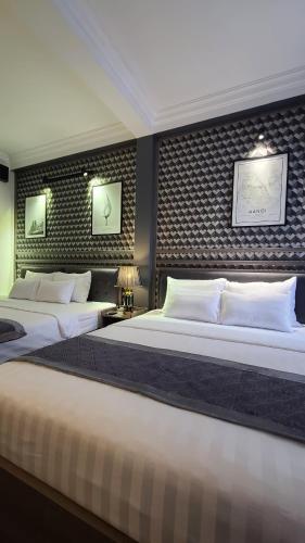 a bedroom with two beds and a wall with two pictures at Hanoi Lucky Hostel in Hanoi