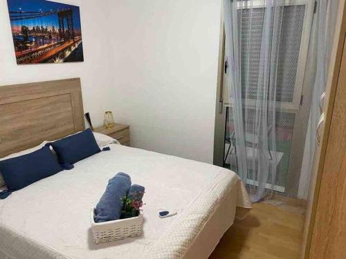 1 dormitorio con 1 cama con almohadas azules en Precioso apartamento en zona de playa, en Almería
