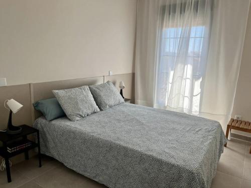 a bedroom with a bed and a large window at Apartamentos El Piquillo en Cadalso de los Vidrios in Cadalso de los Vidrios