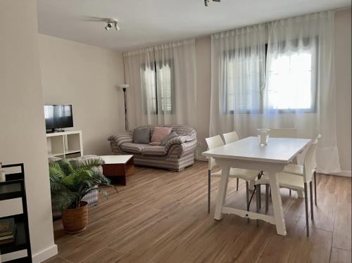 a living room with a white table and a couch at Apartamentos El Piquillo en Cadalso de los Vidrios in Cadalso de los Vidrios