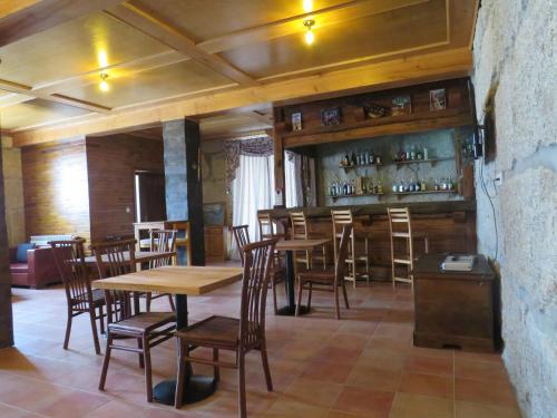 um restaurante com mesas e cadeiras de madeira e um bar em Solar dos Alperces - Serra da Estrela - Turismo de Aldeia em Travancinha