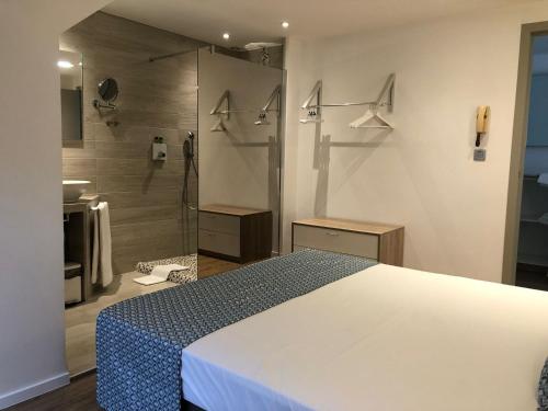 een slaapkamer met een wit bed en een douche bij Shelter-rooms in Buizingen