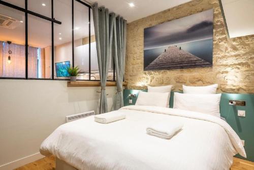 1 dormitorio con 1 cama blanca grande y ventanas en 153 - Urban Pretty Flat in Center of Paris, en París