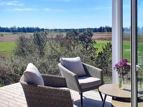 a patio with wicker chairs and a table with a view at 5 person holiday home in R m in Kongsmark