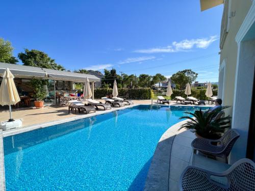 a large swimming pool with chairs and umbrellas at Dna Hotel Dalyan in Dalyan