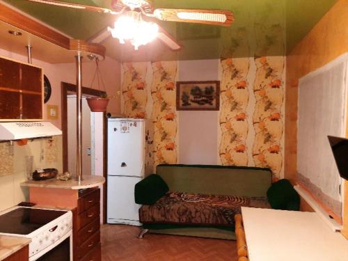 a kitchen with a couch and a refrigerator in a room at Гостевой коттедж 