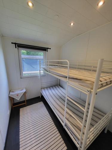 Zimmer mit 2 Etagenbetten und einem Fenster in der Unterkunft Mökki Vanajaveden rannalla Kirstulan Kartanossa in Hämeenlinna
