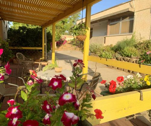 a patio with flowers and a table and chairs at O&B Hospitality - אירוח אלף בית in Metsudat Menahem Ussishkin Alef