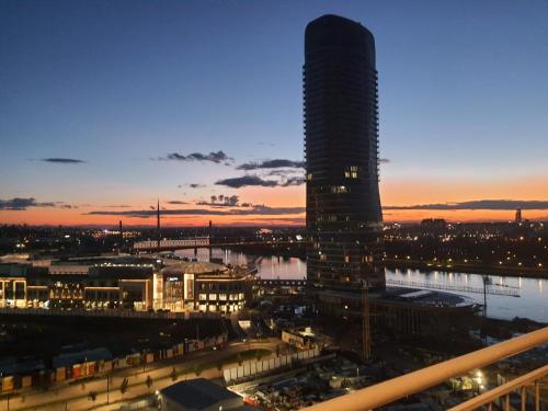 una vista de la ciudad por la noche con un edificio alto en Belgrade Waterfront - Beograd na vodi, en Belgrado