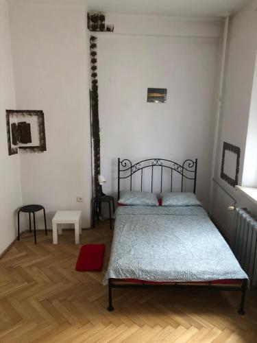a bedroom with a bed and a wooden floor at Pokój 12C in Krakow