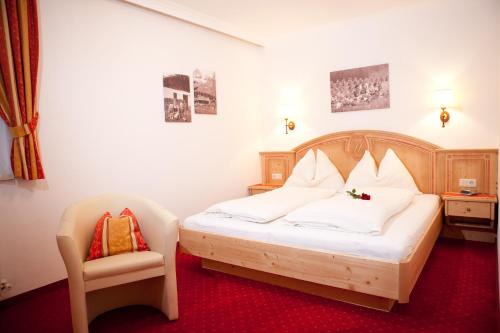 ein Schlafzimmer mit einem Bett und einem Stuhl darin in der Unterkunft Appartement-Gästehaus Ursula in Flachau