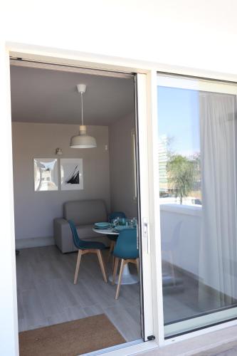 a sliding glass door leading into a living room at Pescoluse Apartments in Marina di Pescoluse