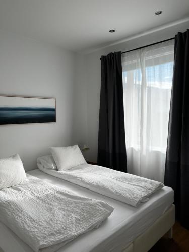 two beds in a room with a window at Seydisfjördur Apartment in Seyðisfjörður