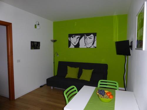 sala de estar verde con mesa y sofá en Appartamento Giulio VI, en Turín