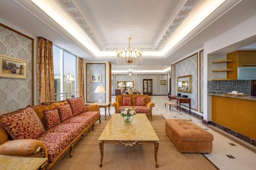 Dusit Hotel & Suites - Doha في الدوحة: غرفة معيشة مع كنب وطاولة