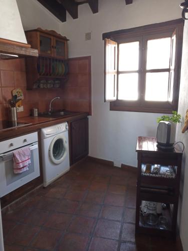 a kitchen with a washing machine and a window at Luz y Sol in Jimena de la Frontera