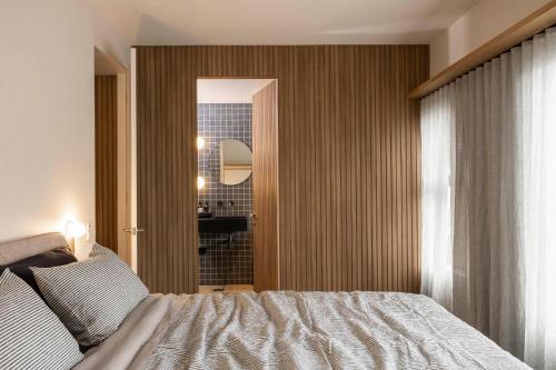 a bedroom with a bed and a door to a bathroom at John and Jane's Beechworth in Beechworth