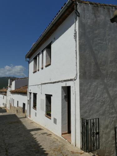 biały budynek z drzwiami i oknami w obiekcie Luz y Sol w mieście Jimena de la Frontera